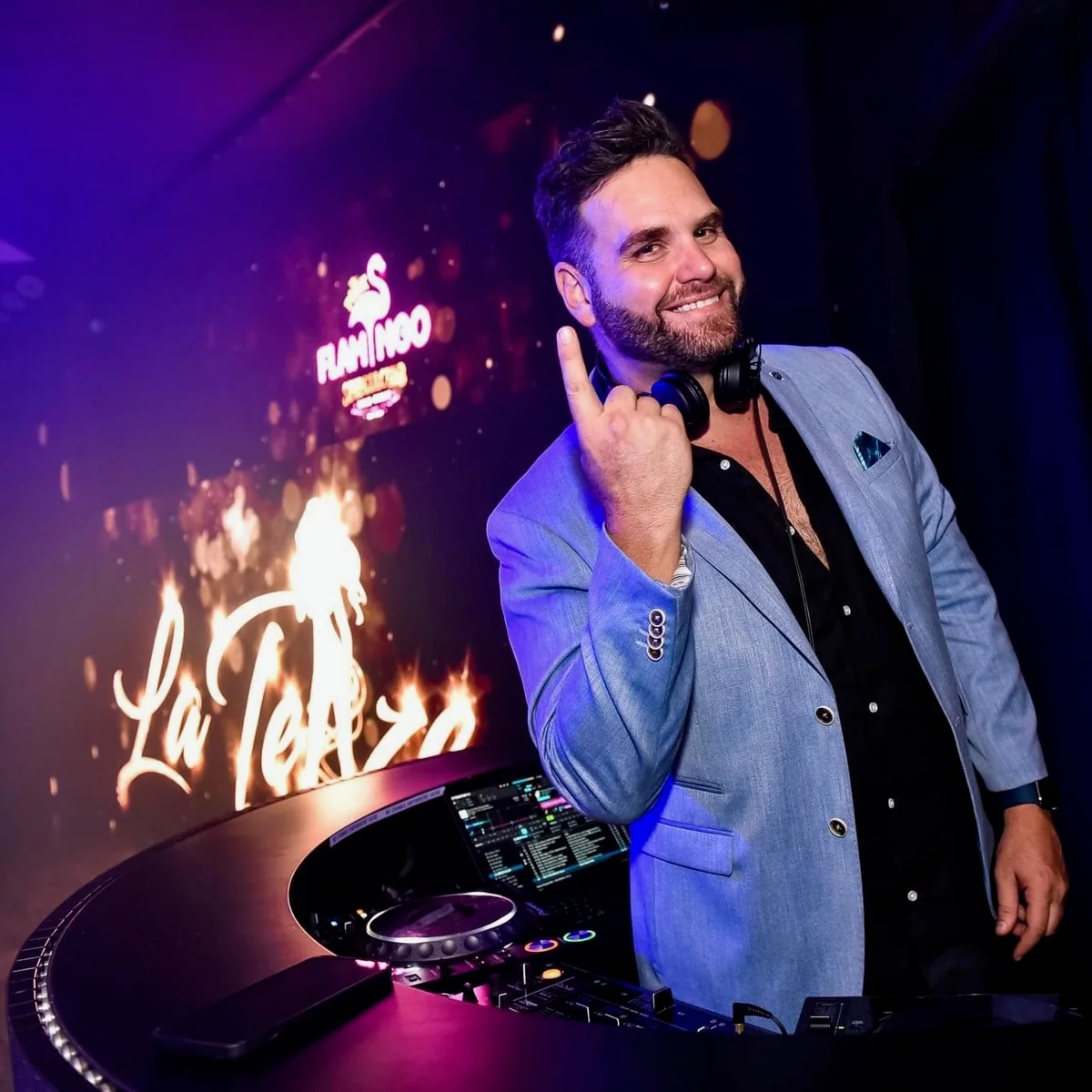 Sean smiling in a blazer behind the decks at Pink Flamingo in 2021.