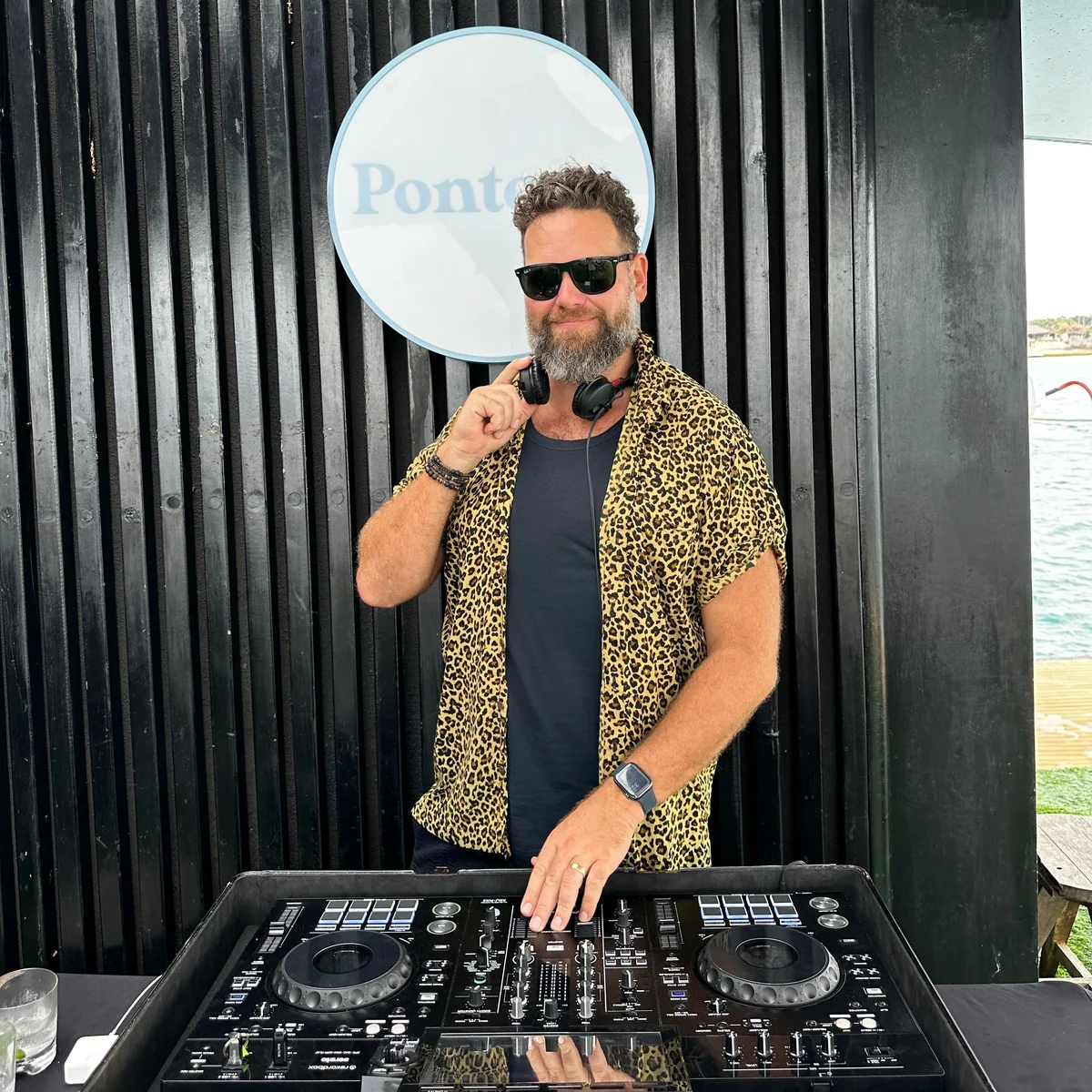 Sean in sunglasses and a patterned shirt behind the decks at Pontoon Bali in 2024.