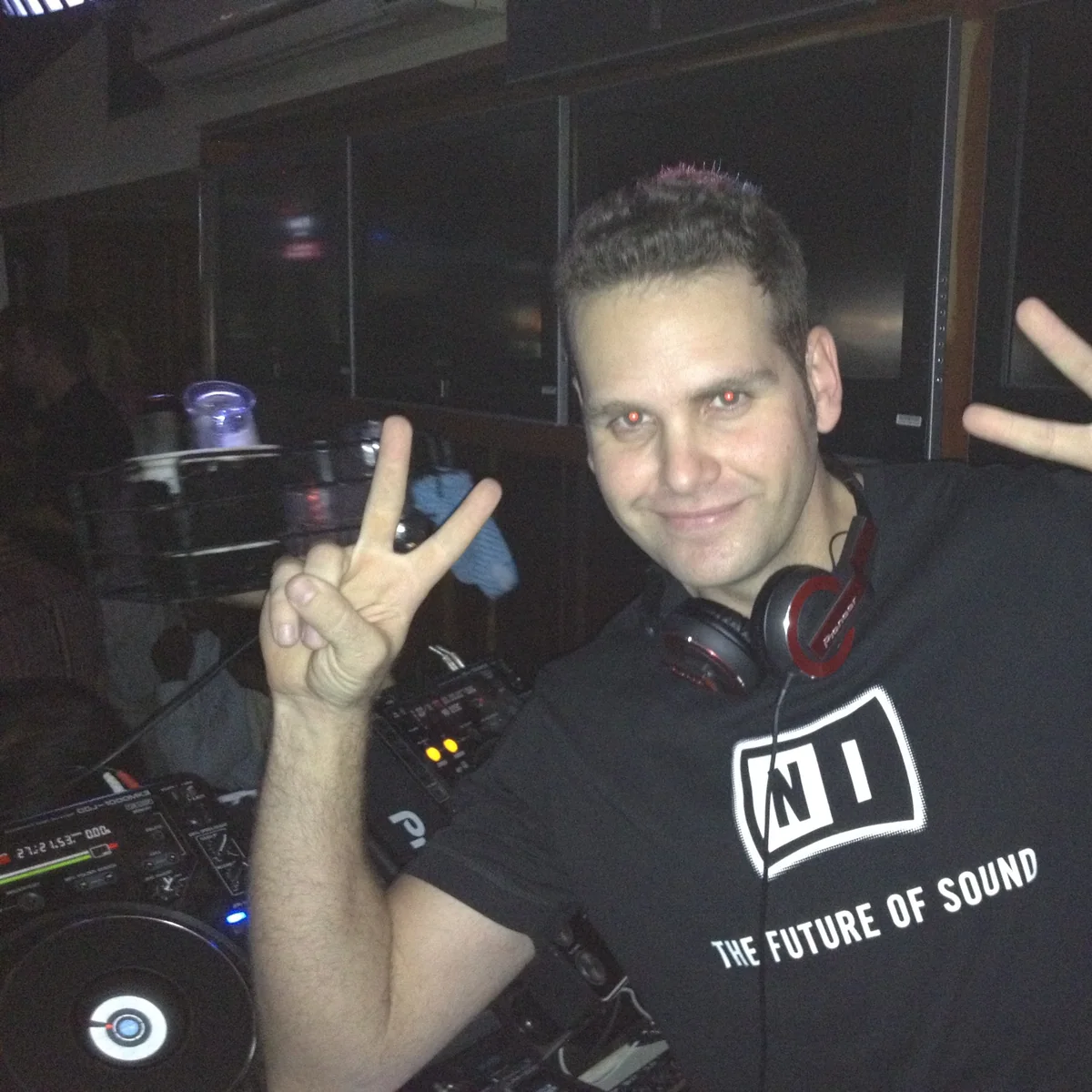 Sean in the DJ booth at RG's in 2010, smiling and holding up both hands.